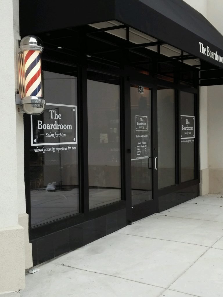 Black-framed glass storefront doors at barbershop entrance