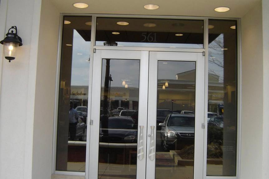 Glass storefront doors on building with stone facade